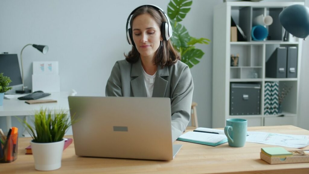 Person using headphones and a laptop for voice typing