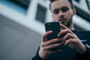 Person holding an iPhone while reviewing app privacy settings